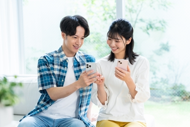 スマホで情報収集をする若い男女