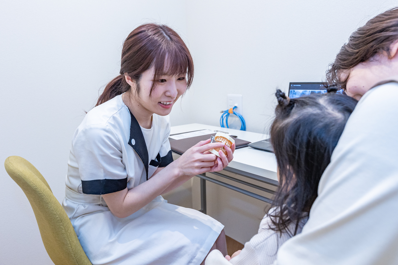 あゆみ歯科クリニックのスタッフが親子に歯科指導しているところ
