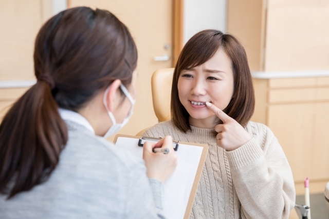 歯のトラブルで受診した女性が問診を受けているところ