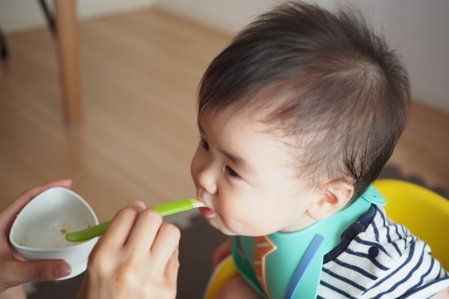 離乳食を食べる赤ちゃんのイメージ。スプーンで口に運ぶ瞬間。