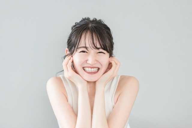 歯が白く歯並びの良い若い女性