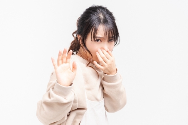 臭さに距離をとる若い女性