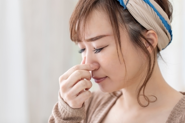 臭いに鼻をふさぐ女性