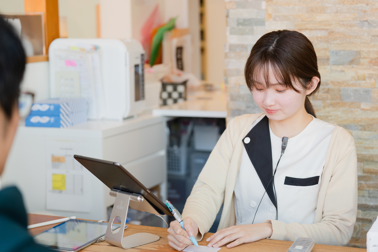あゆみ歯科クリニックの受付スタッフが患者対応をしているところ